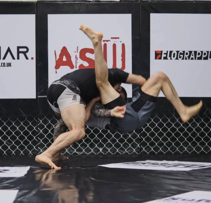 Wrestling takedown against the cage